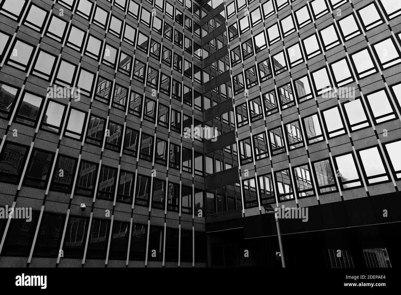 Guardando verso l'edificio degli uffici a Londra con riflessi in bianco e nero monocromatico Foto Stock