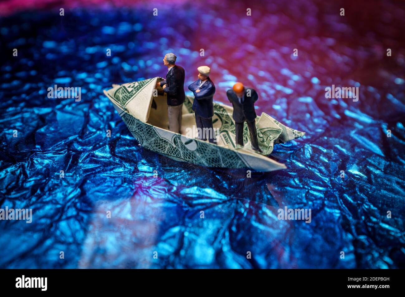 Miniatura imprenditori di figurine di giro sul dollaro origami yacht Foto Stock