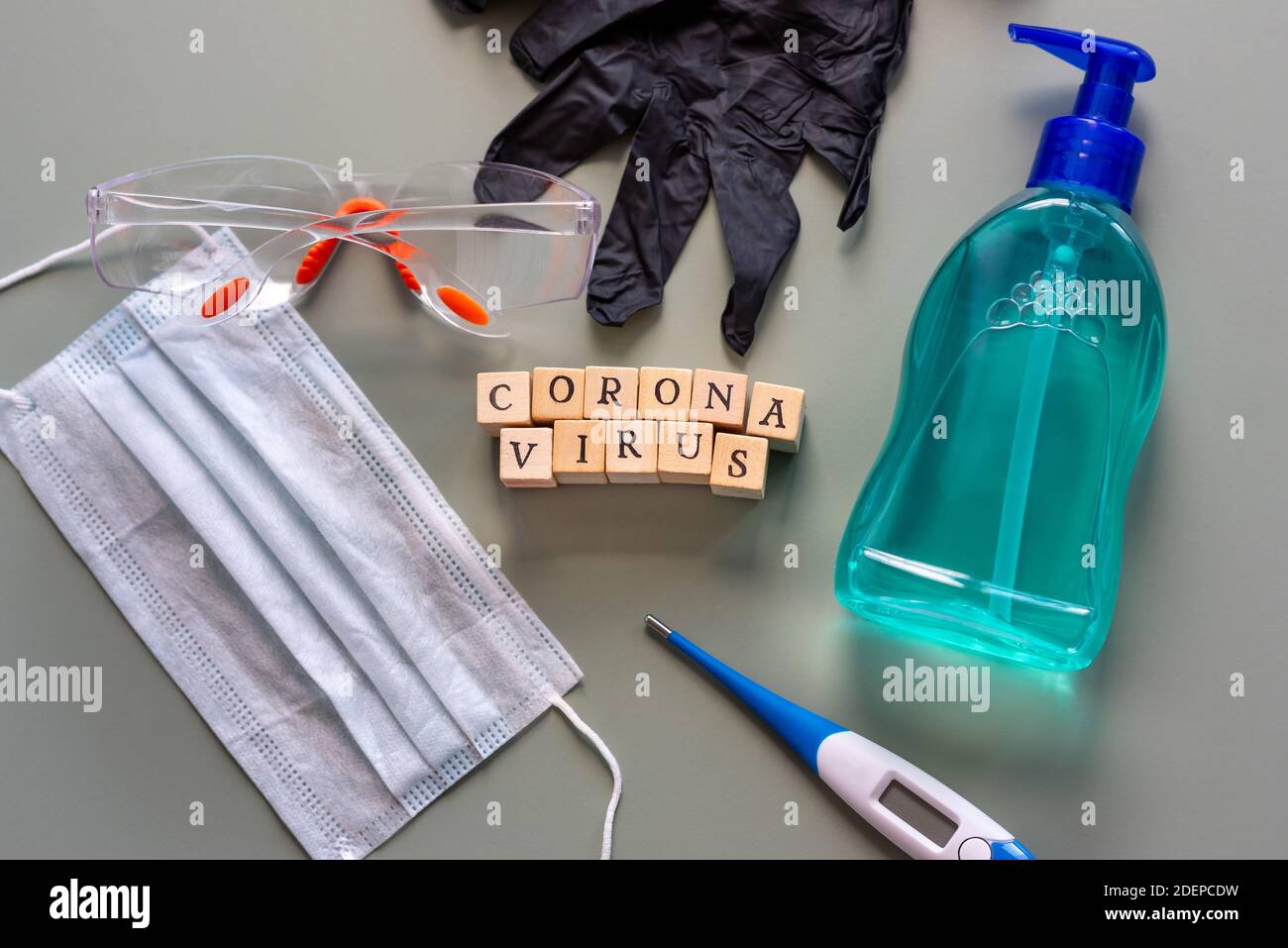 Gli strumenti necessari per proteggersi dal coronavirus in una posa piatta con maschera chirurgica, guanti, disinfettante per le mani, occhiali di protezione e un thermom Foto Stock