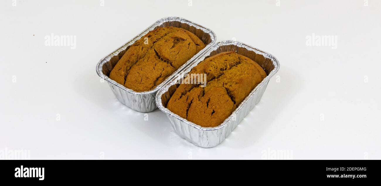 Immagine orizzontale di due pani di zucca appena sfornati in argento latta con sfondo bianco Foto Stock