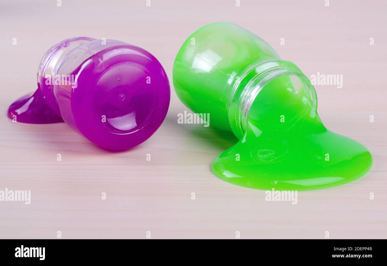Bright multi slimes colorati su un tavolo. I ragazzi più popolari del giocattolo al giorno d'oggi. Il fango in contenitori di plastica. Foto Stock