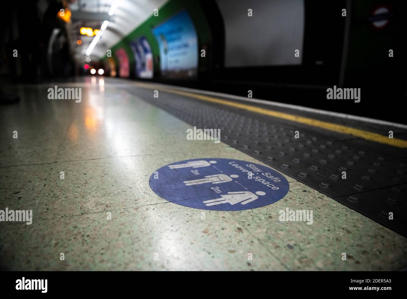 Covid-19 Coronavirus lockdown social distancing segno di informazioni e guida per rimanere a 2 m di distanza a Londra sui trasporti pubblici alla stazione della metropolitana in Inghilterra, Regno Unito Foto Stock