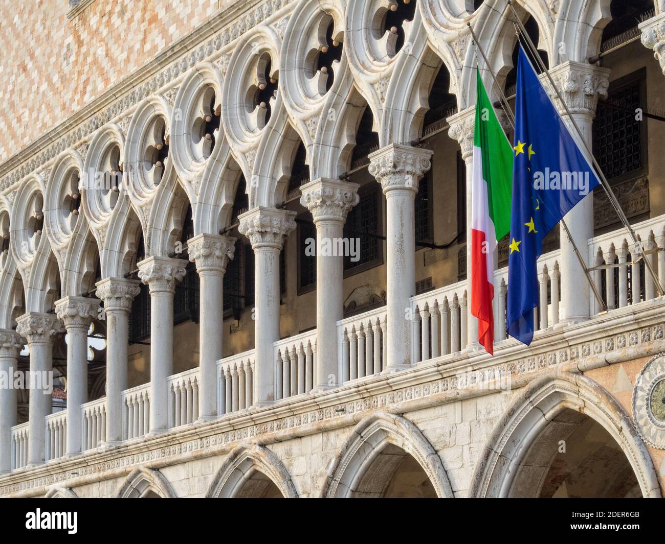 Bandiere italiane ed europee appendono rom la loggia del Palazzo Ducale sopra la galleria al piano terra - Venezia, Veneto, Italia Foto Stock