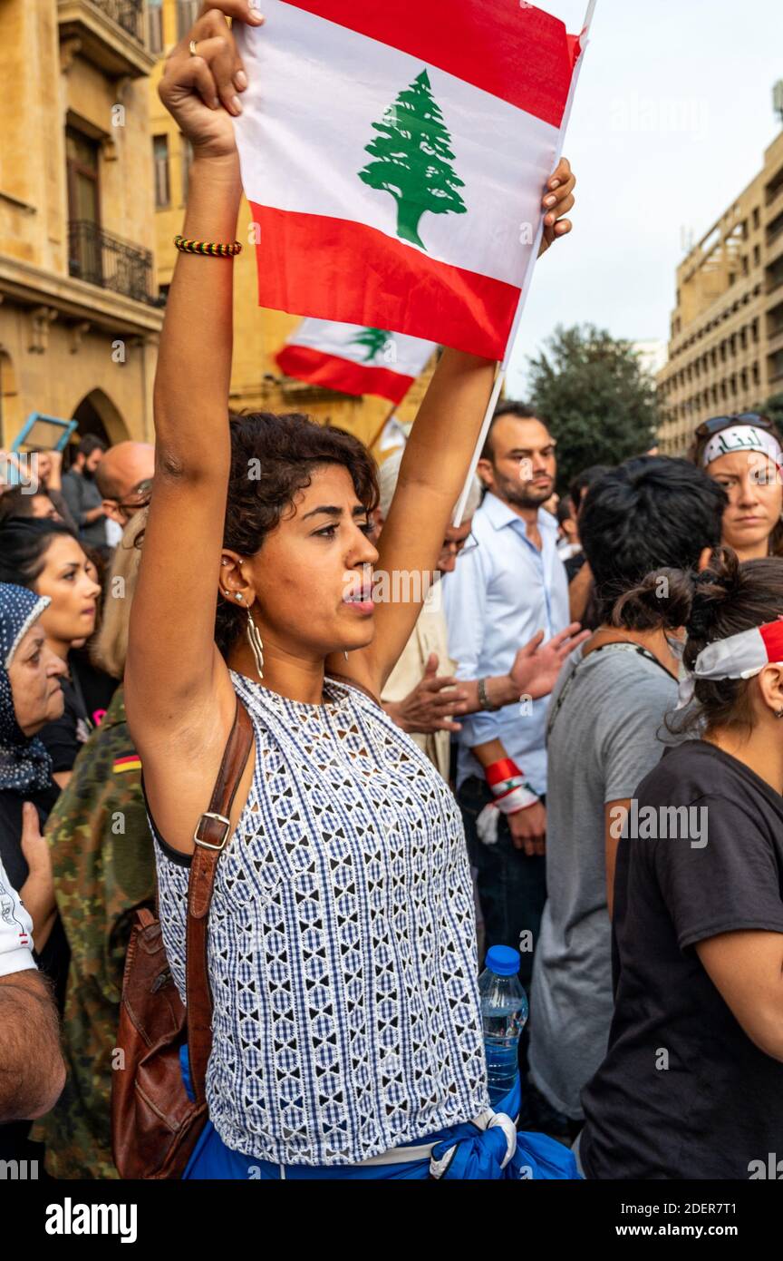 Una donna solleva bandiera libanese durante il confronto con i sostenitori di Hezbollah, in una protesta che si è svolta a Beirut, in Libano, il 25 ottobre 2019. È il nono giorno delle proteste che è iniziato dopo la decisione del governo di tassare le chiamate su ‘WhatsApp’ e altre applicazioni telefoniche, nonché contro la corruzione dei partiti politici. Foto di Ammar Abd Rabbo/ABACAPRESS.COM Foto Stock