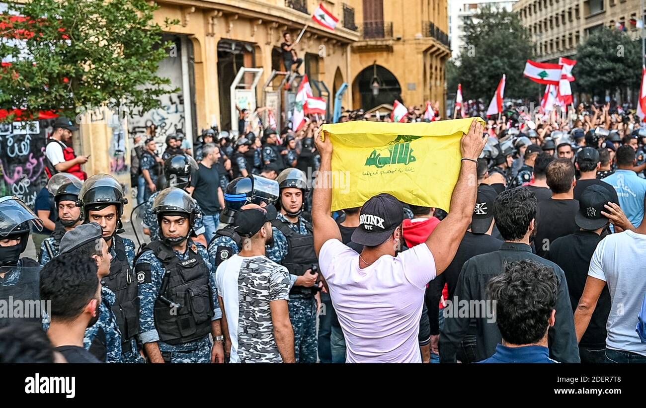 Un sostenitore di Hezbollah solleva la bandiera (gialla) del suo partito che si trova di fronte ai manifestanti durante le manifestazioni che si svolgono a Downtown Beirut, in Libano, il 25 ottobre 2019. È il nono giorno delle proteste che è iniziato dopo la decisione del governo di tassare le chiamate su ‘WhatsApp’ e altre applicazioni telefoniche, nonché contro la corruzione dei partiti politici. Foto di Ammar Abd Rabbo/ABACAPRESS.COM Foto Stock