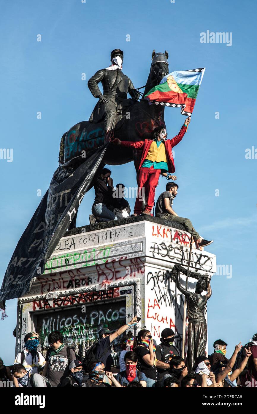 Un uomo vestito come la protesta Joker sul Monumento del Generale Baquedano a Plaza Italia, Santiago, il 30 ottobre 2019, a Santiago, Cile, durante la protesta contro il governo del Presidente Sebastian Pinera. Il presidente Sebastian Pinera ha annunciato misure per migliorare la disuguaglianza sociale, tuttavia i sindacati hanno chiesto uno sciopero a livello nazionale e dimostrazioni massicce continuano quando il numero delle vittime ha raggiunto i 18. Tra le richieste alla base delle proteste vi sono questioni quali l'assistenza sanitaria, il sistema pensionistico, la privatizzazione dell'acqua, i trasporti pubblici, l'istruzione, la mobilità sociale e la corruzione. Foto di Fabien Dupuoux/ABACAPRESS.COM Foto Stock