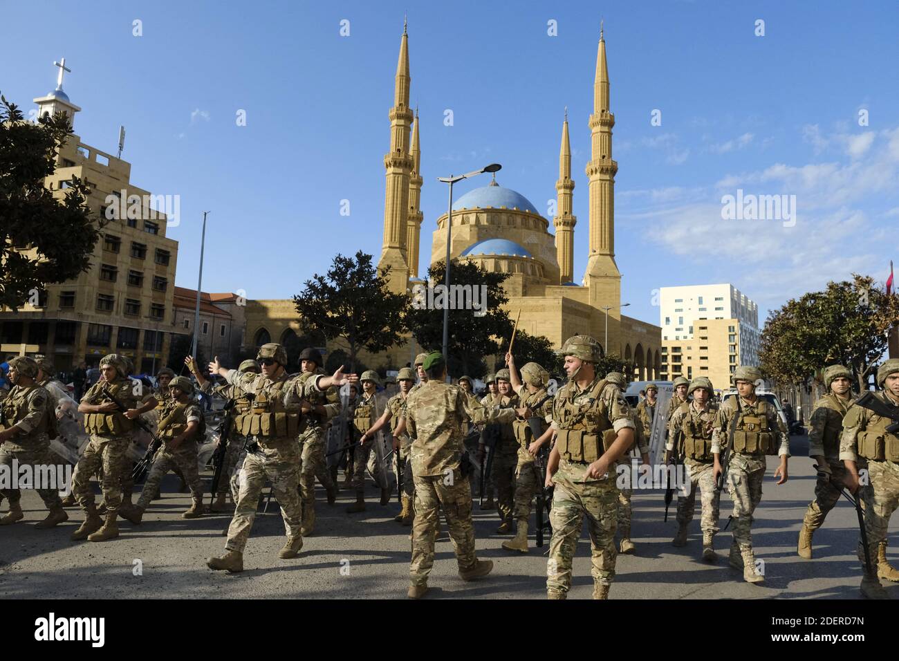 L'esercito e le forze di sicurezza libanesi contengono scontri tra dimostranti e contromanifestanti da parte di sostenitori pro-iraniani Hezbollah che hanno attaccato i manifestanti nel centro della capitale Beirut durante il 13° giorno di proteste anti-governative, decine di riotatori sono scesi in piazza Riad al-Solh vicino al quartier generale del governo a Beirut, dove attaccarono i manifestanti, tormentarono le tende, e si aggredirono le bandiere che invocavano la "rievoluzione". L'attacco senza precedenti sul sito principale del movimento di protesta della capitale, in gran parte pacifico, ha costretto l'esercito e la polizia antisommossa a dispiegare in massa per contenere la violenza Foto Stock