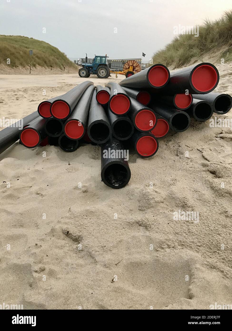 Un primo piano della nuovissima costruzione in plastica nera lunga tubi sul terreno sabbioso Foto Stock