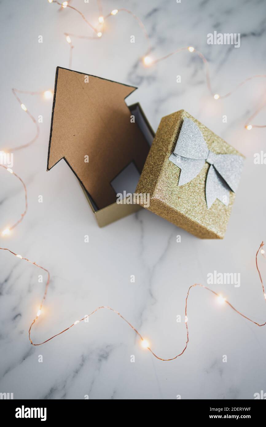 acquistare o investire in una nuova immagine concettuale della casa, icona della casa all'interno della scatola aperta presente circondata da luci fairy Foto Stock