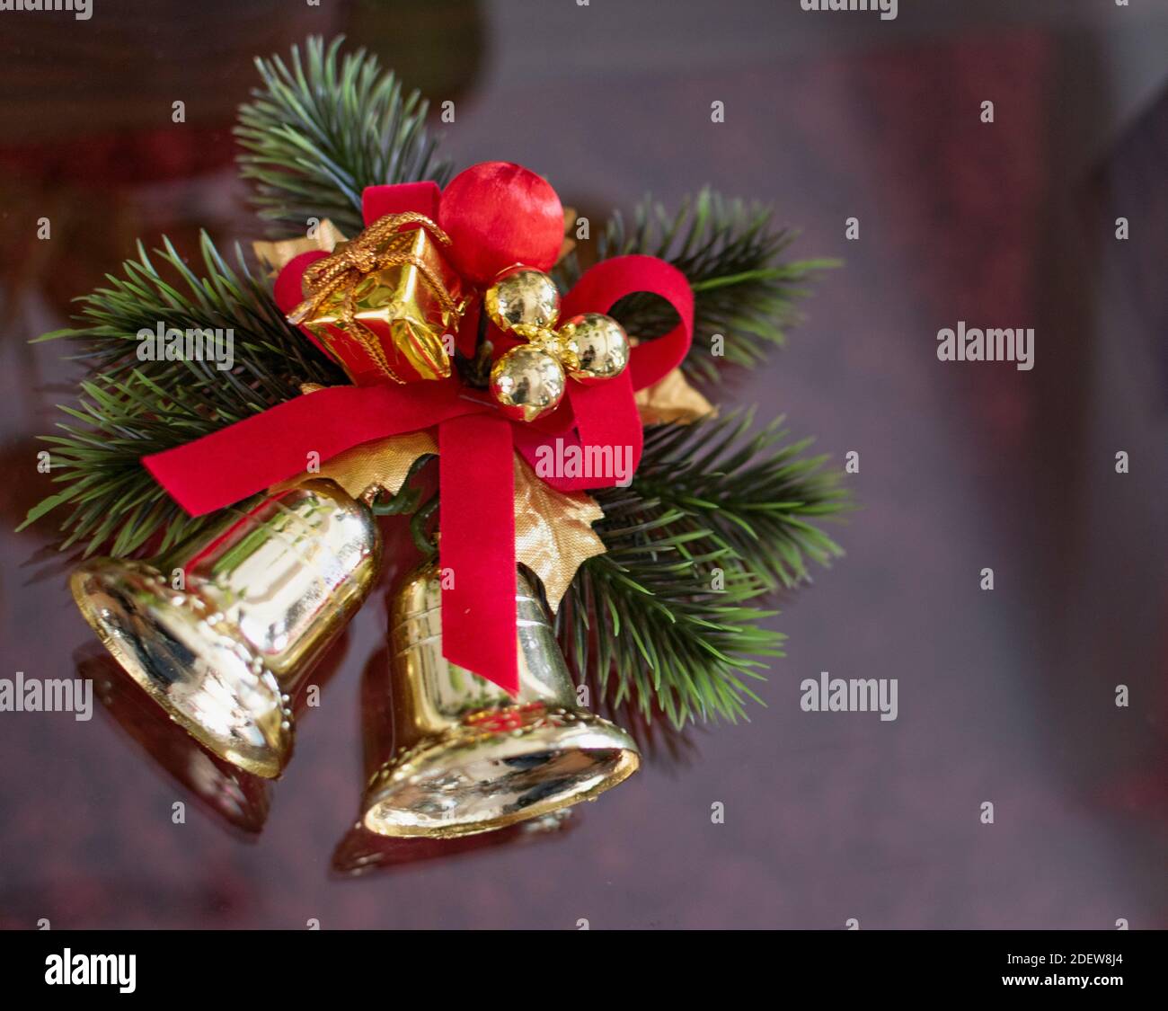 Un ornamento di Natale su un tavolo. Un paio di campane dorate che decorano. Foto Stock