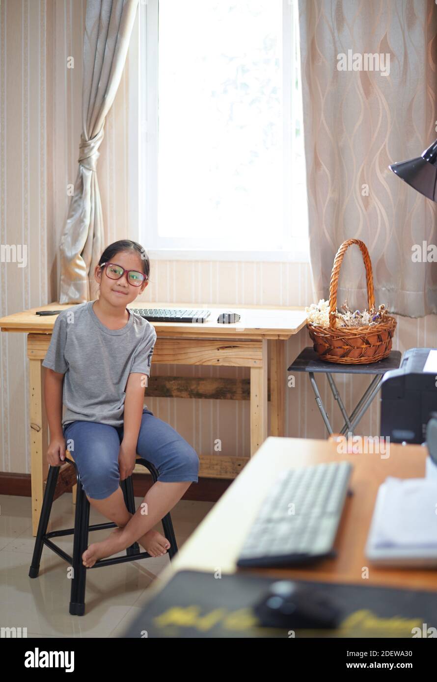 Ritratto di ragazza seduta davanti al suo tavolo da lavoro Foto Stock