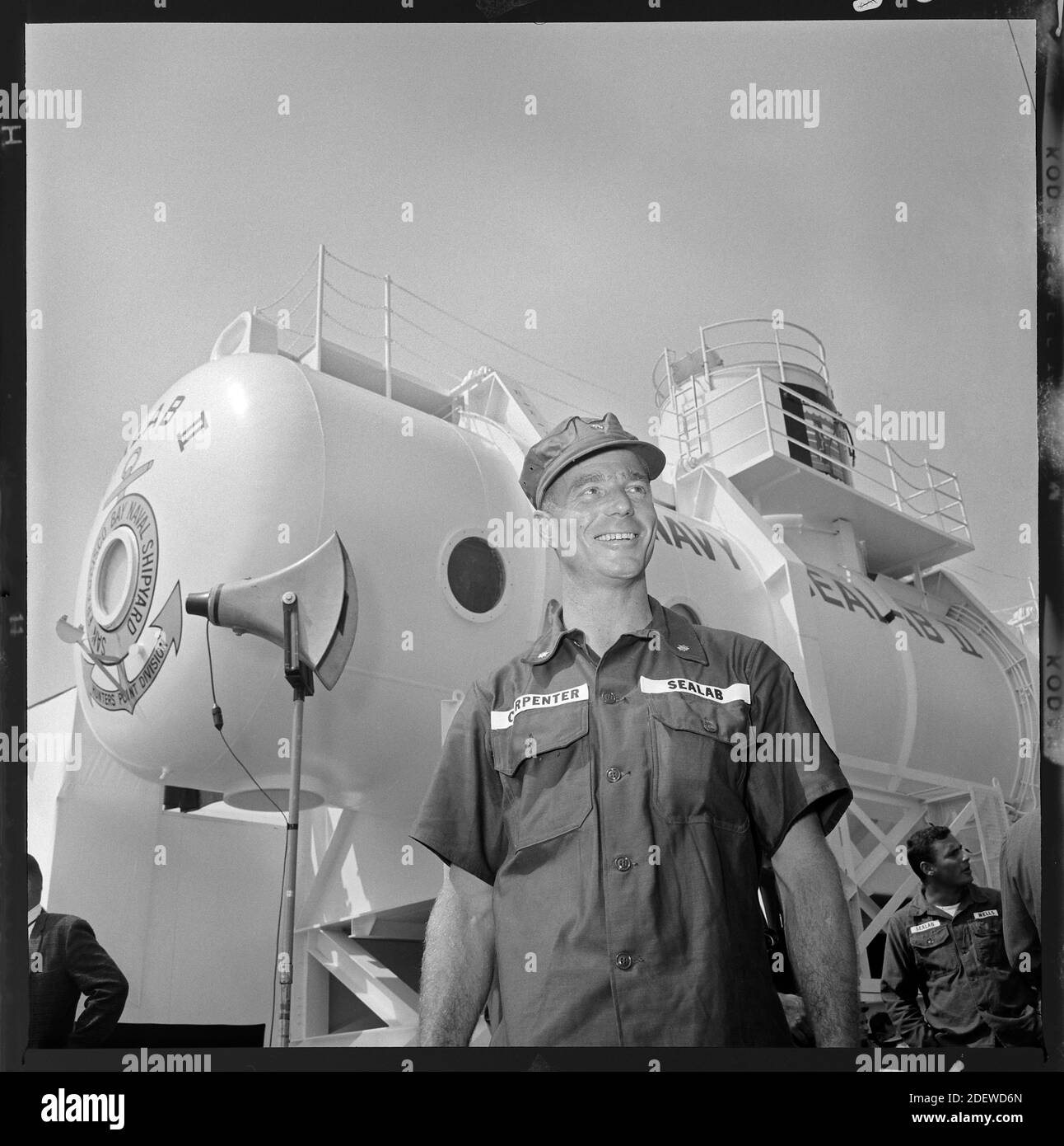 Astronauta e aquanaut, Scott Carpenter si erge di fronte a Sealab II L'habitat di ricerca subacquea è stato collocato al largo della costa di la Jolla, California nel 1965. Immagine da 6x6 cm negativo. Foto Stock