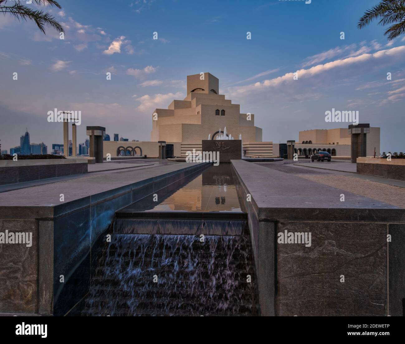 Museo d'Arte Islamica a Doha, Qatar in luce diurna con vista esterna ad angolo basso con fontana in primo piano e nuvole nel cielo sullo sfondo Foto Stock