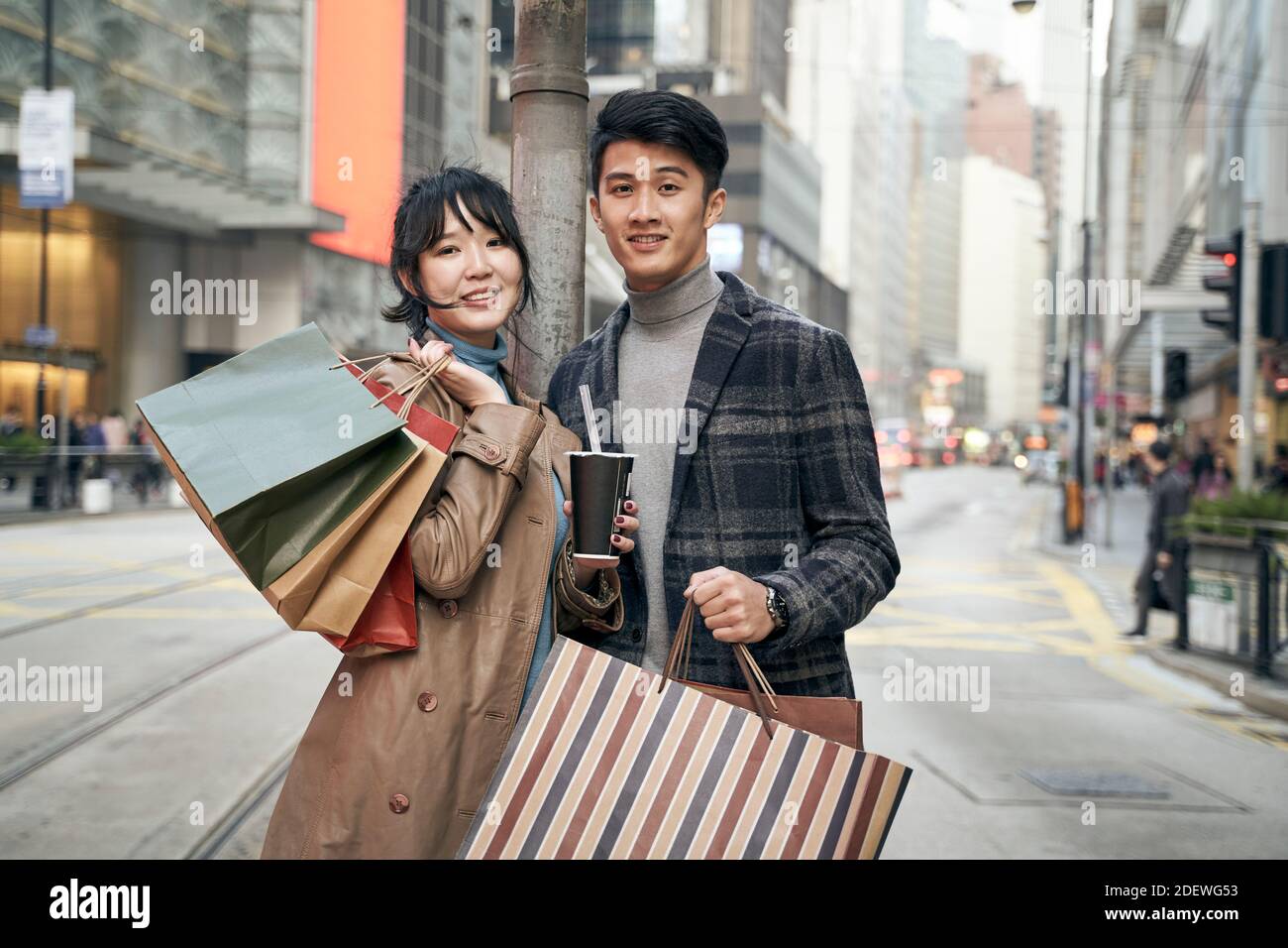 ritratto esterno di una giovane coppia asiatica con borse per la spesa in mano Foto Stock
