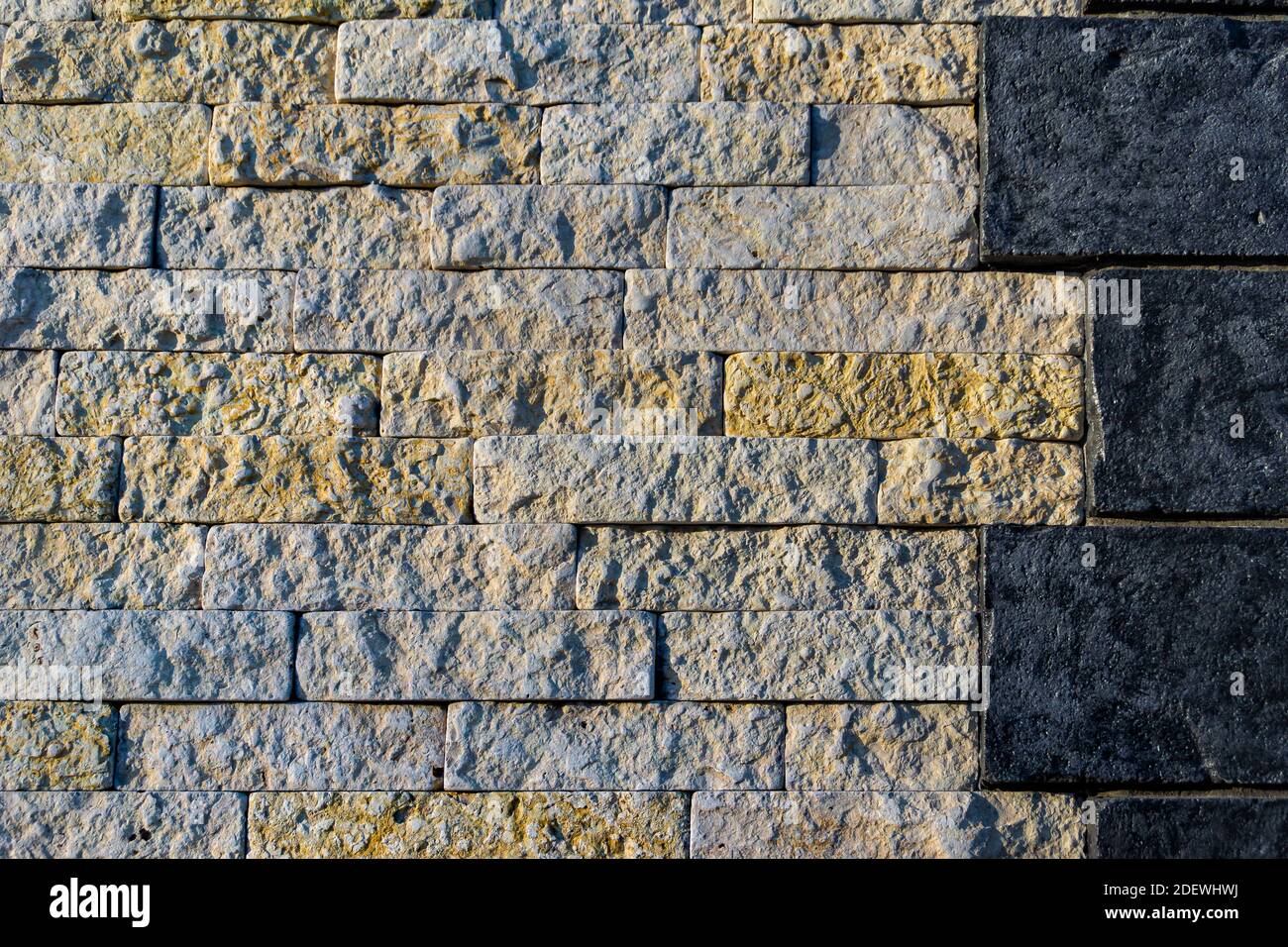 l'unione di pareti in pietra di due diversi tipi di pietra - scura e chiara, di grandi e medie dimensioni Foto Stock
