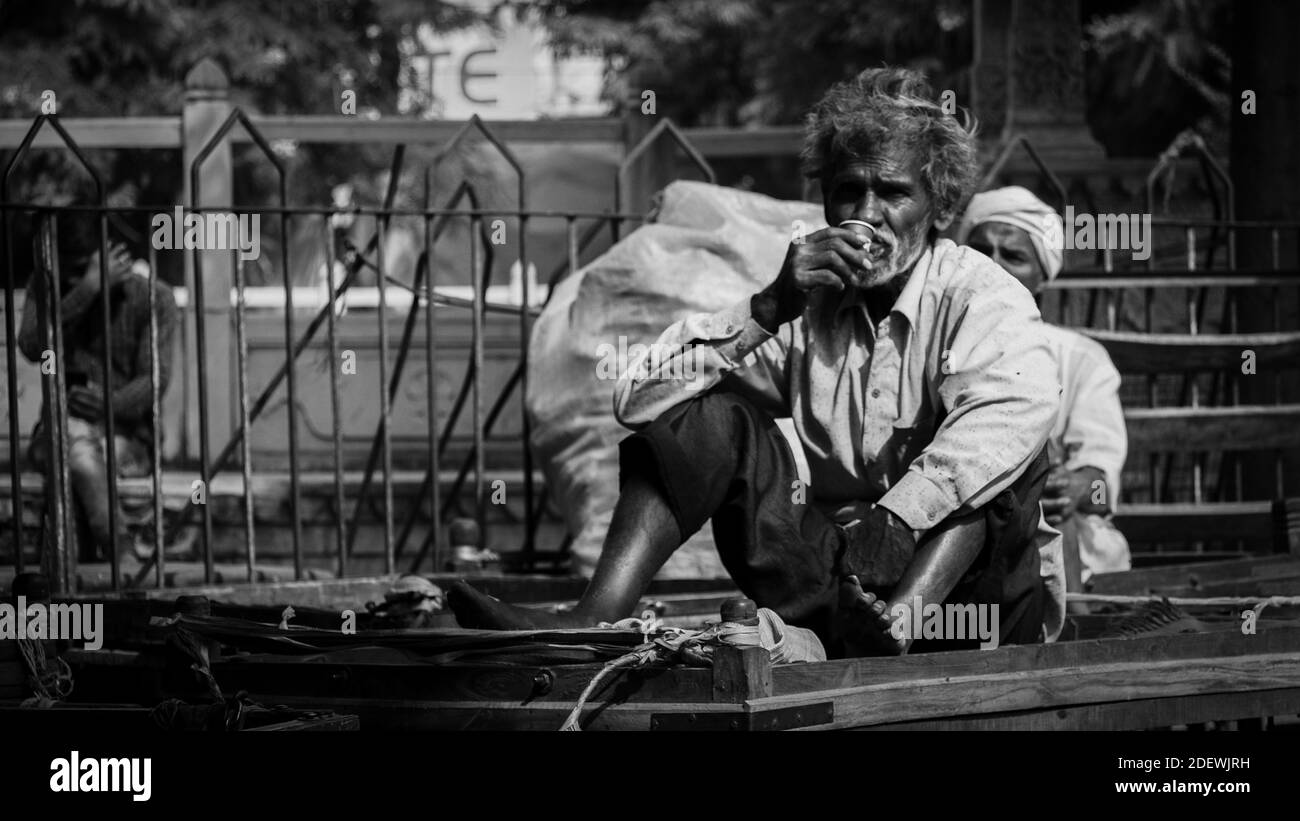 Un uomo è seduto e ha un chai (tè indiano) a Bundi, India. Foto Stock