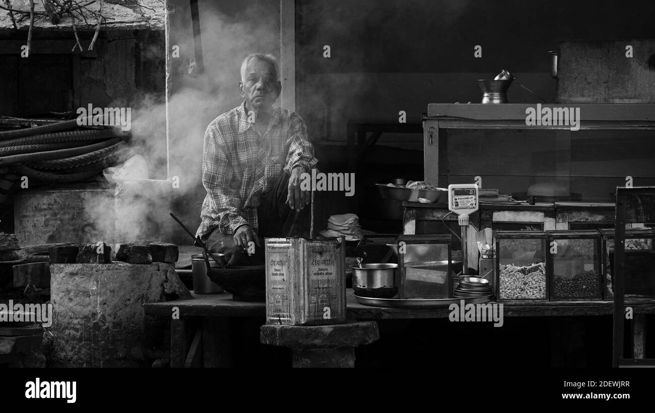 Un uomo sta cucinando cibo di strada a Bundi, India. Foto Stock