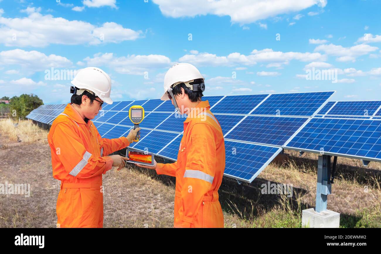 Il tecnico porta la scansione ThermoScan (termocamera) al pannello solare per un controllo della temperatura, dal concetto alla tecnologia utilizzata per controllare il danno in Foto Stock