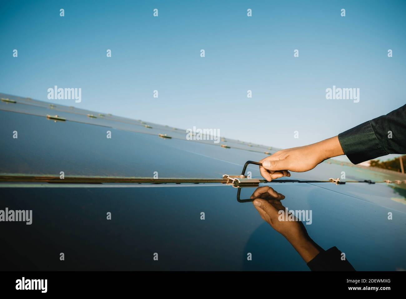 I tecnici utilizzano il cacciavite esagonale per fissare il dado esagonale per fissare i pannelli solari appena installati, energia alternativa per risparmiare energia mondiale, Pho Foto Stock
