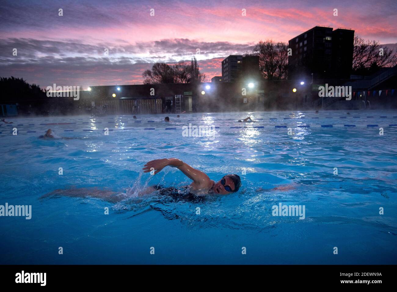 Nuotatori durante l'alba al Lido di Charlton a Hornfair Park, Londra, il suo primo giorno di riapertura dopo la fine della seconda chiusura nazionale e l'Inghilterra entra in un sistema rafforzato di restrizioni regionali di coronavirus. Foto Stock