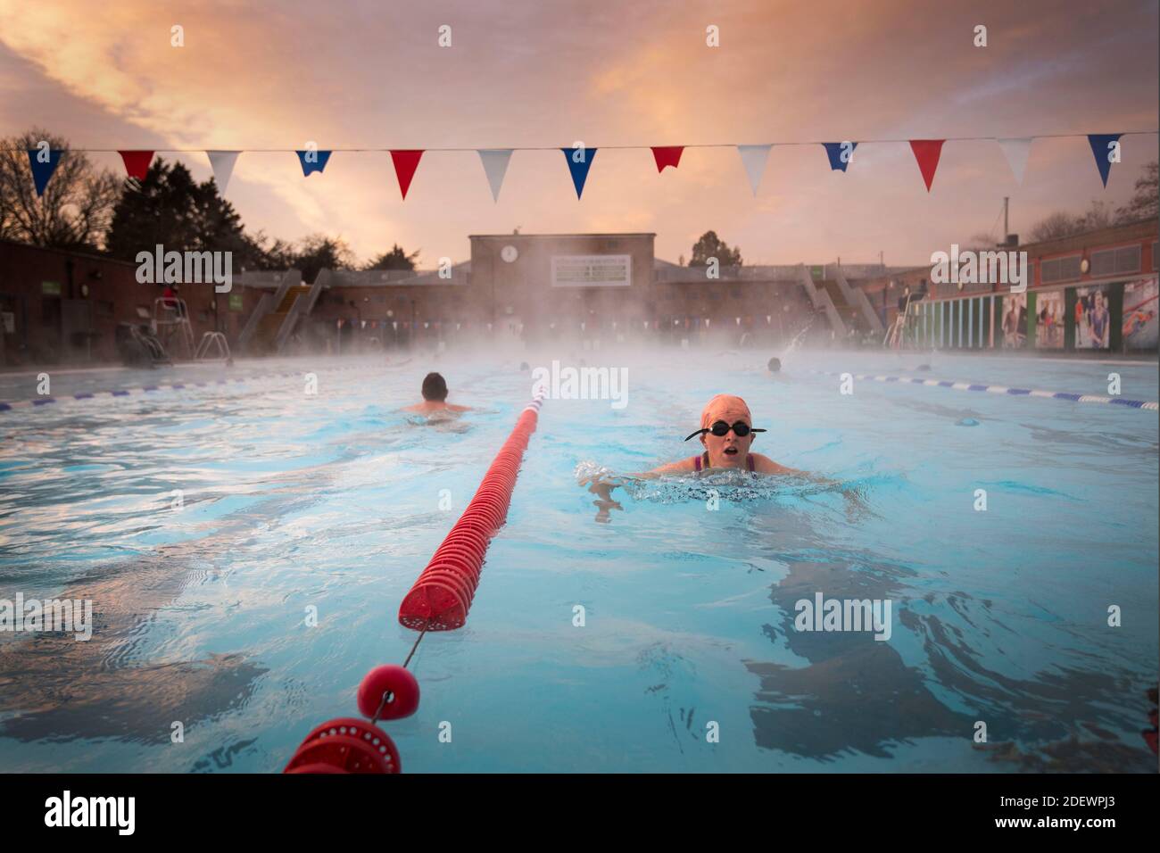 Nuotatori al mattino presto durante l'alba al Lido di Charlton a Hornfair Park, Londra, il suo primo giorno di riapertura dopo la fine della seconda chiusura nazionale e l'Inghilterra entra in un sistema rafforzato di restrizioni regionali al coronavirus. Foto Stock