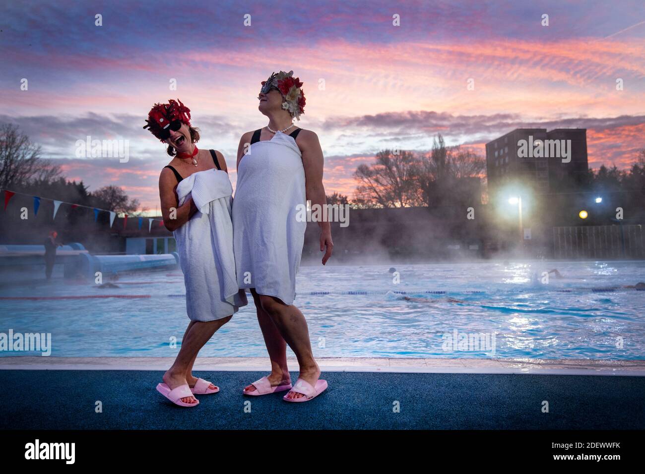 Jessica Walker e Nicola Foster, noti come Lido Ladies, posano presso la piscina durante l'alba prima di nuotare a Charlton Lido in Hornfair Park, Londra, il suo primo giorno di riapertura dopo la fine del secondo blocco nazionale e l'Inghilterra entra in un sistema rafforzato di restrizioni regionali di coronavirus. Foto Stock