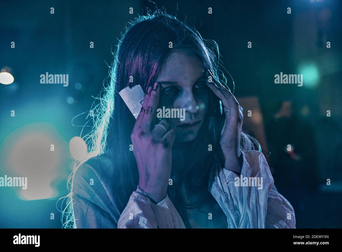 Ragazza teen con trucco per la celebrazione di Halloween in luce blu al neon. Foto Stock