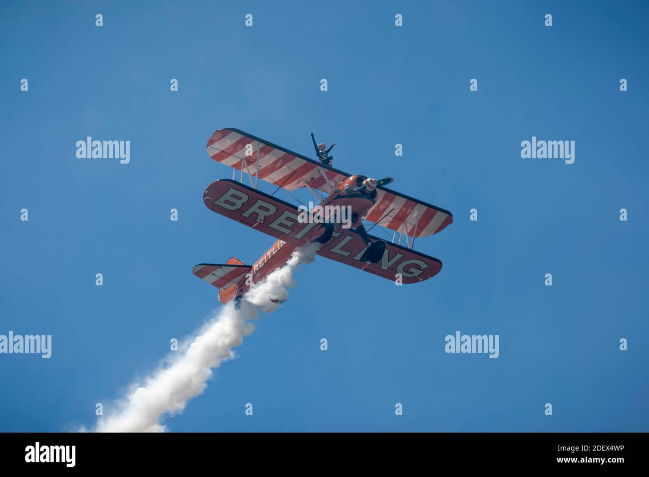 Boeing Barnstormer Breitling aereo Wingwalker in volo con piste di fumo Foto Stock