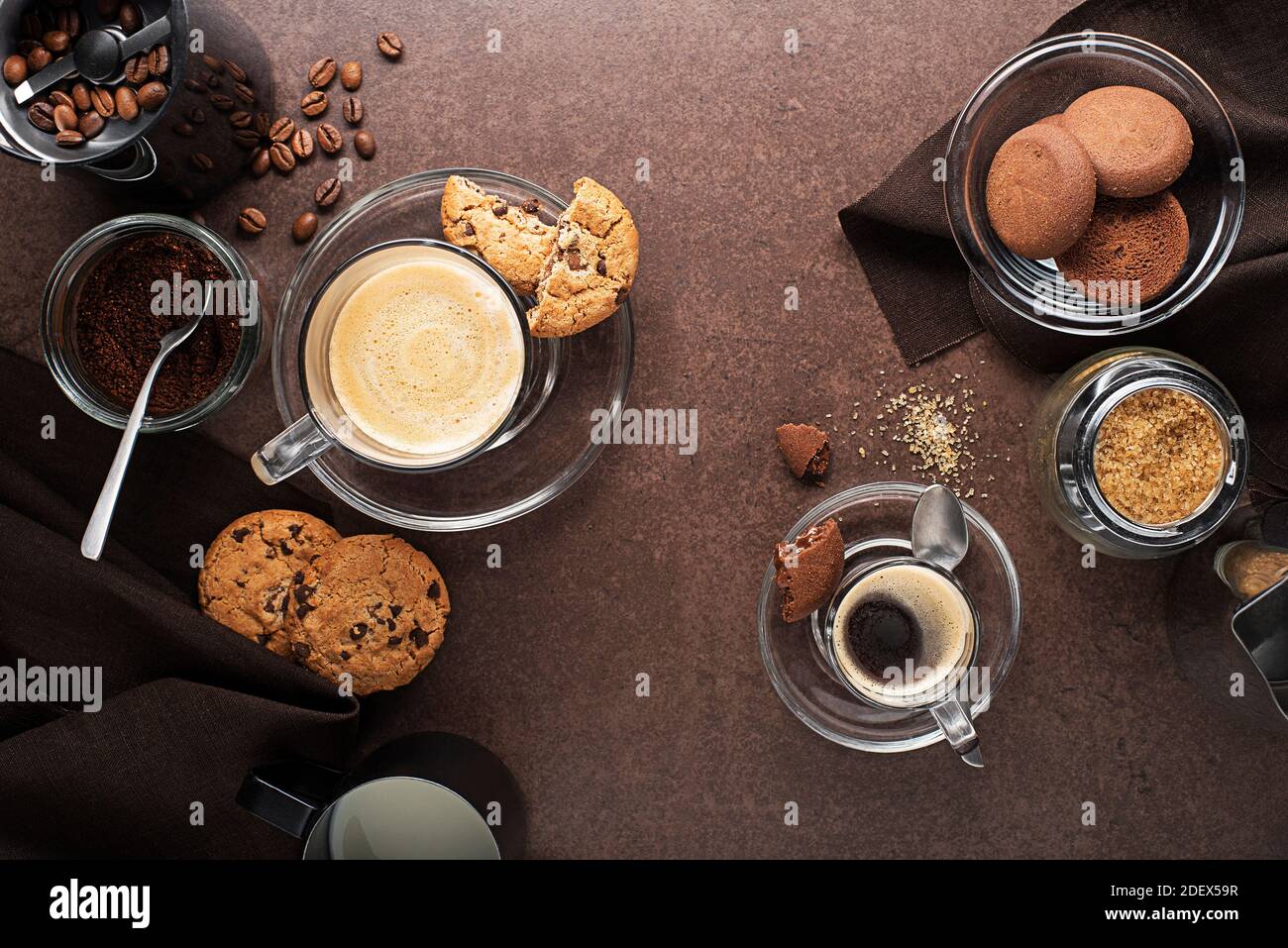 Tazze di caffè espresso e cappuccino con chicchi di caffè e. macinacaffè su tavolo scuro Foto Stock