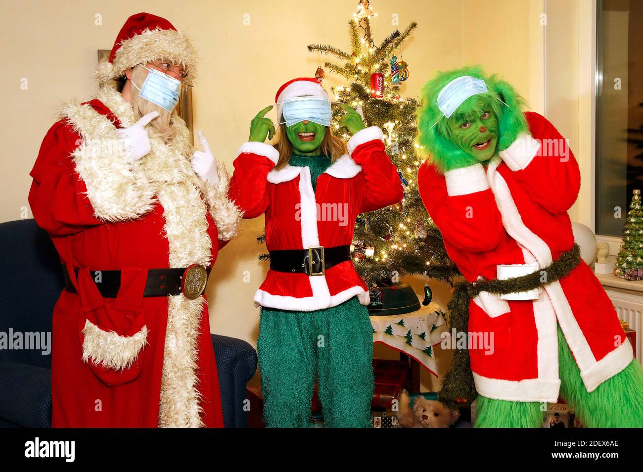 Il Weihaftertsmann cerca di spiegare ai Grinch e alla signora Grinch come indossare correttamente una maschera protettiva. GEEK ART - Bodypainting e Transformaking: 'Il Grinch ruba Weihafterten' Fotocirefare con Enrico Lein come Grinch, Maria Skupin come Frau Grinch e Fabian Zesiger come Weihaftertmann in Villa Czarnecki. Hamelin, 30 novembre 2020 - un progetto del fotografo Tschiponnique Skupin e del body painter e trasformatore Enrico Lein | uso in tutto il mondo Foto Stock