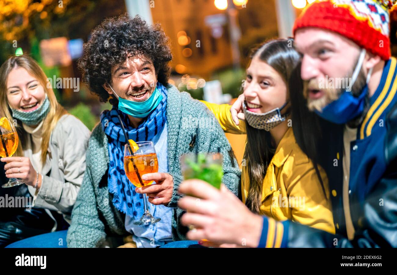 Amici che bevono spritz e mojito al cocktail bar aperto Maschera facciale - nuovo concetto di stile di vita normale con persone felici divertirsi insieme Foto Stock