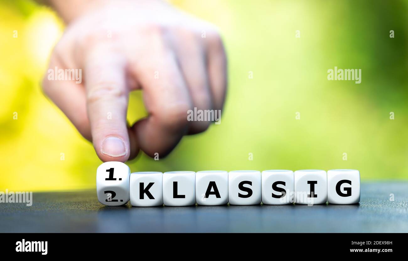 La mano trasforma i dadi e cambia l'espressione tedesca '2. Klassig' (seconda classe) in '1. Klassig' (prima classe). Foto Stock