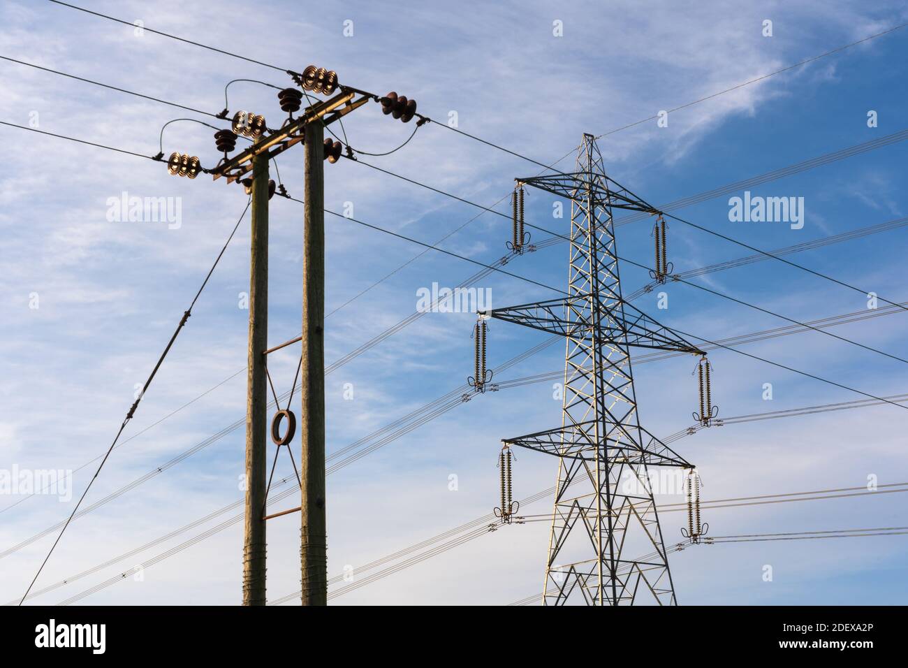 Esempi di due tralicci di elettricità. Traliccio in acciaio e pilone in legno. Hertfordshire. REGNO UNITO Foto Stock