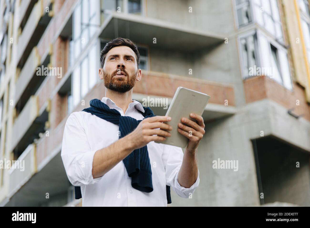 Architetto focalizzato che utilizza il tablet nel cantiere Foto Stock