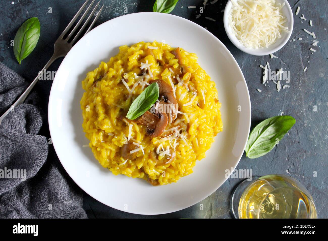 Risotto italiano con funghi, zafferano e parmigiano su fondo scuro. Vista dall'alto con spazio per la copia. Foto Stock