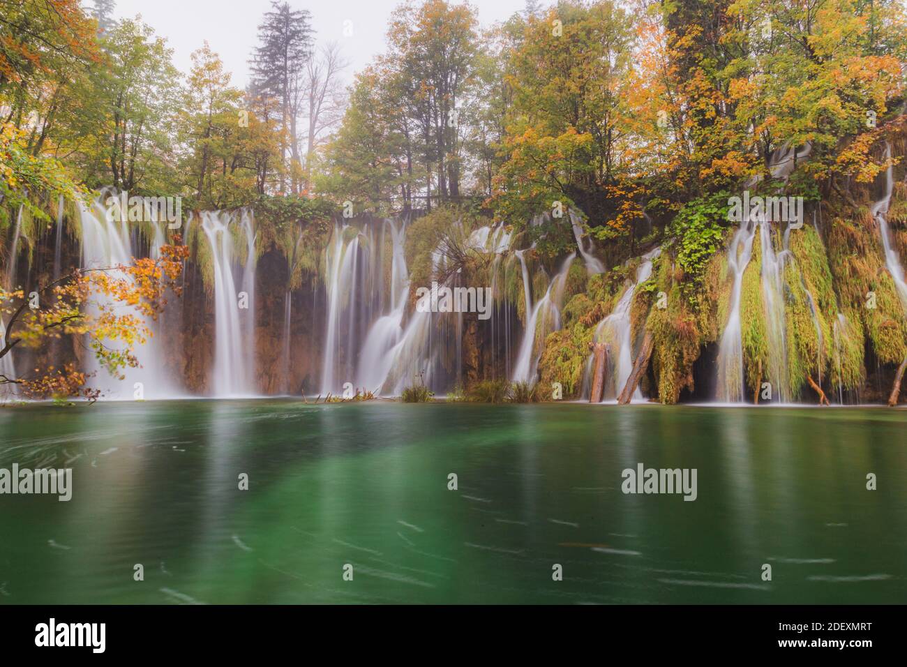 Le cascate fluiscono in una piscina color smeraldo presso i laghi di Plitvice Croazia Foto Stock