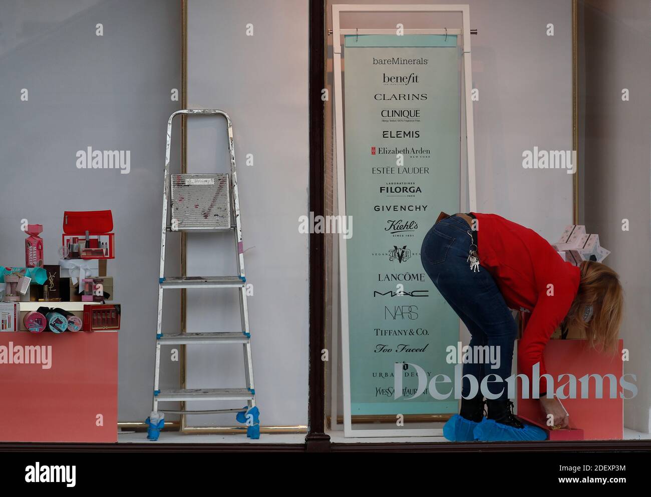 Nottingham, Nottinghamshire, Regno Unito. 2 dicembre 2020. Un lavoratore rimuove la visualizzazione di una finestra di Debenhams dopo che la catena di grandi magazzini è crollata ma ha aperto i suoi negozi per una vendita di liquidazione dei titoli. Credit Darren Staples/Alamy Live News. Foto Stock