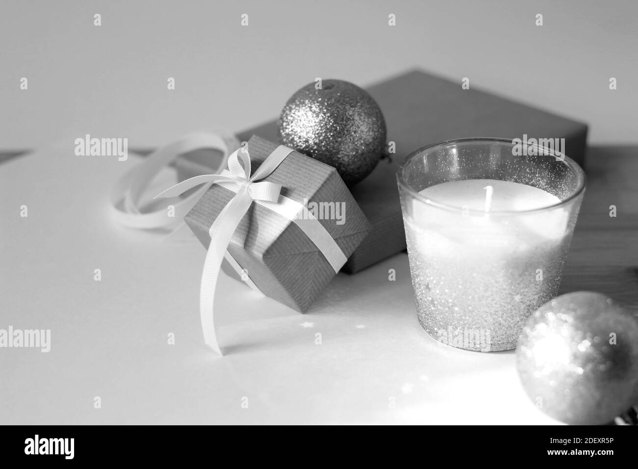 Composizione di Natale di scatola di regalo decorata, ornamenti lucidi, candela. Foto Stock