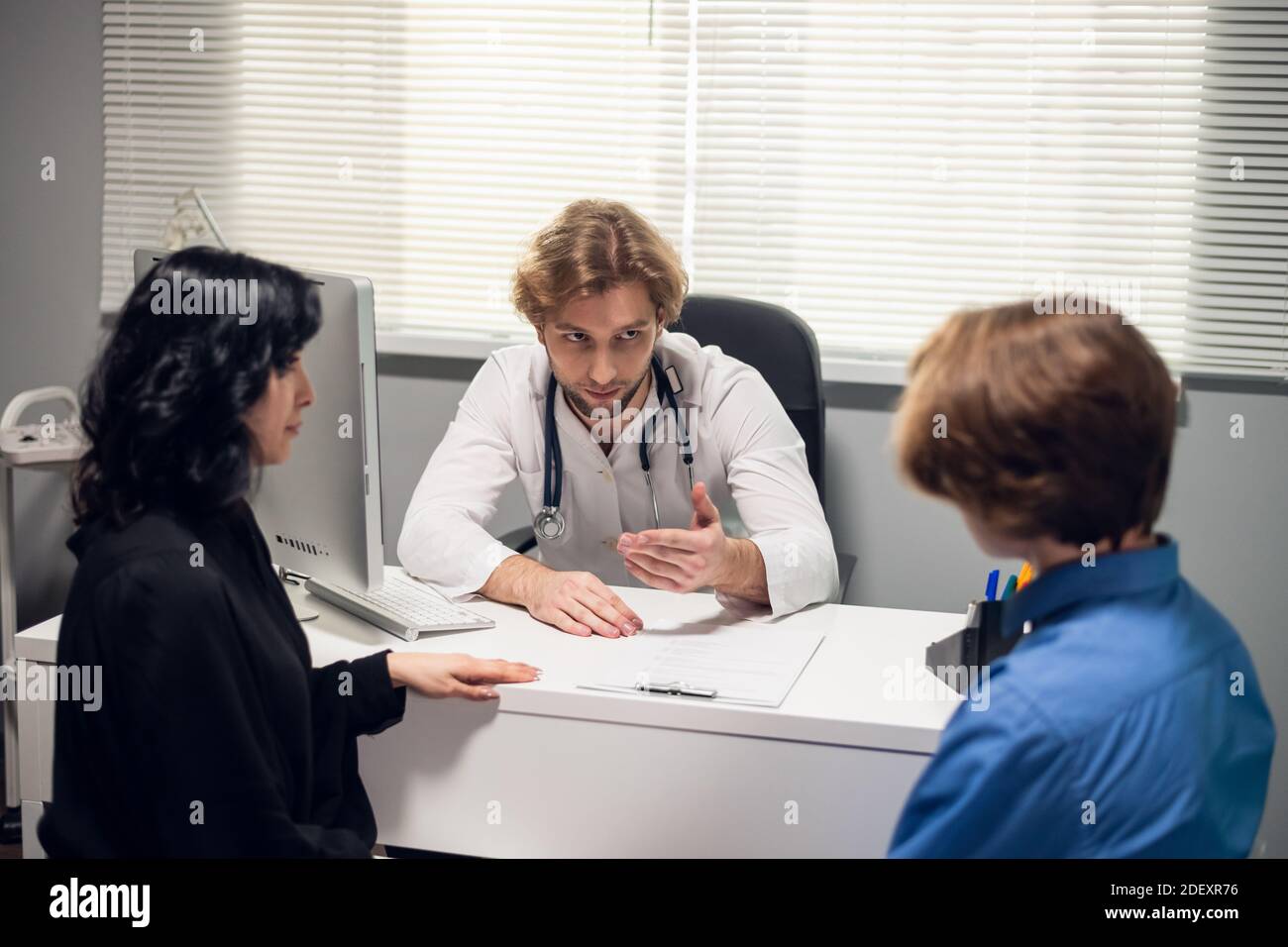 Una madre preoccupata che ascolta i consigli degli esperti medici. Foto Stock