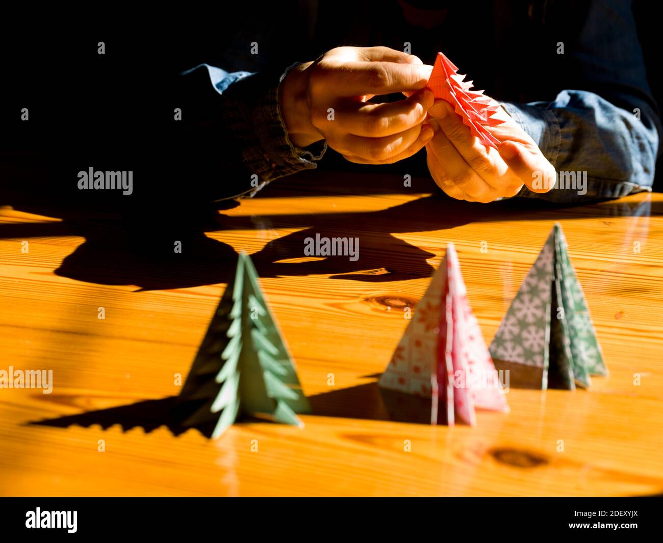 Creazione di regali di Natale decorazioni con alberi di Natale. Realizzata con le tue mani. Vista dall'alto del tavolo in legno con le mani femminili. Artigianato tempo libero per WO Foto Stock