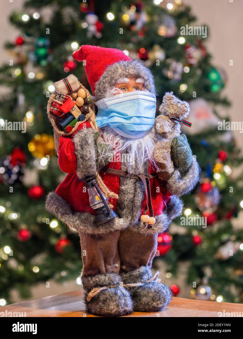 Babbo Natale con maschera di fronte all'albero di Natale - covid sicuro pronto per Natale 2020 Foto Stock