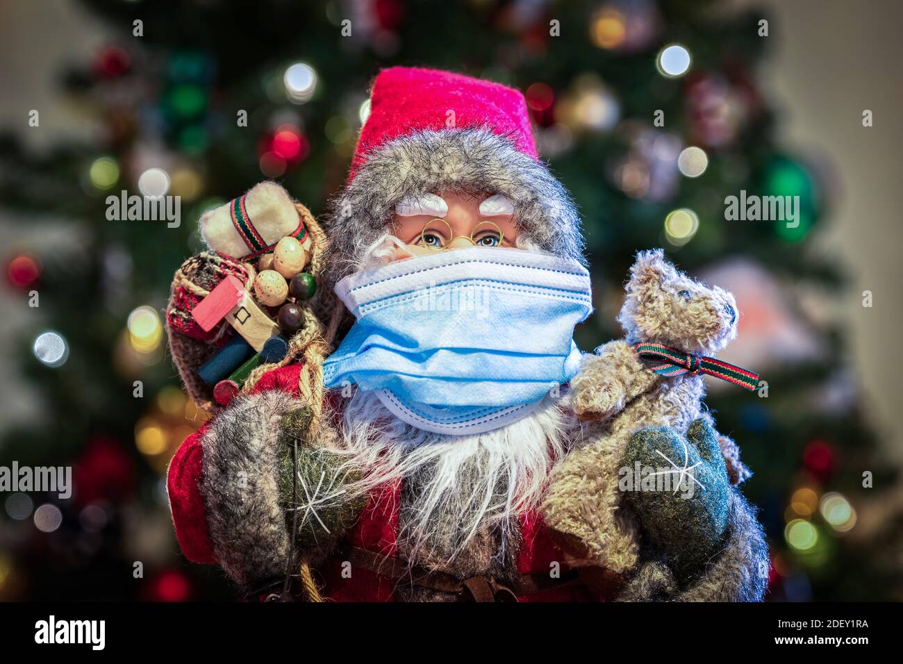 Babbo Natale con maschera di fronte all'albero di Natale - covid sicuro pronto per Natale 2020 Foto Stock