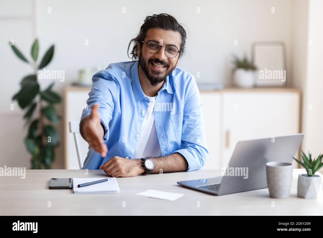 Concetto di partnership. Sorridente imprenditore maschio indiano che si estende la mano per Handshake a Camera Foto Stock