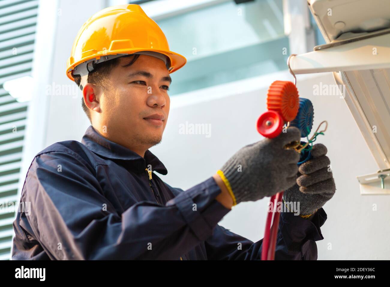 La pompa a vuoto del tecnico evacua e controlla il climatizzatore e il concetto di assistenza post-vendita Foto Stock