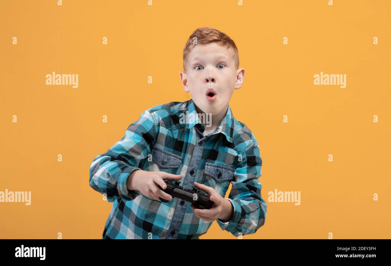 Ragazzo eccitato che gioca a un videogioco con joystick, spazio di copia Foto Stock