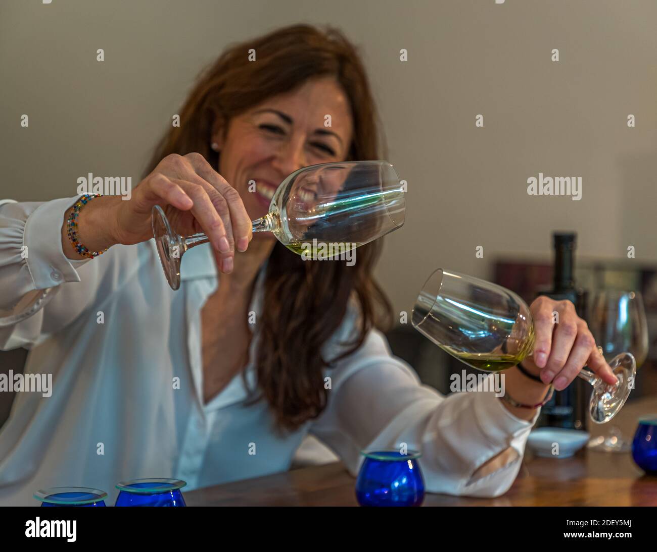 Ridendo, Carmen Sánchez García confronta due bicchieri di olio d'oliva durante una degustazione privata di olio d'oliva a Pulheim vicino a Colonia, Renania Settentrionale-Vestfalia, Germania. Foto Stock