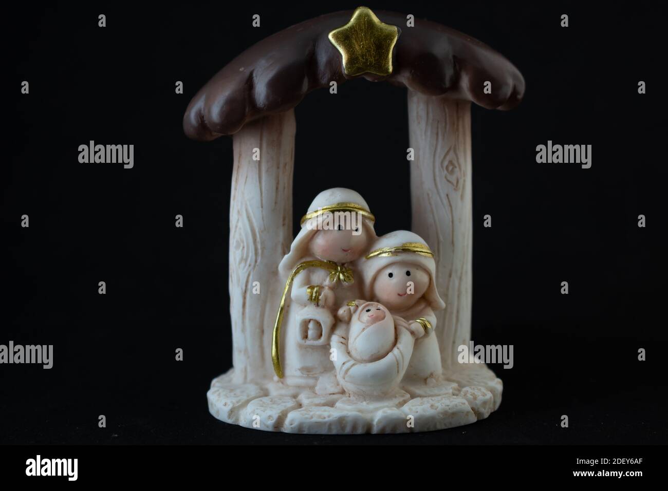 Rappresentazione di un presepe natalizio con le piccole figure di Gesù bambino, Maria e Giuseppe su sfondo nero. Concetto di Natale. Foto Stock