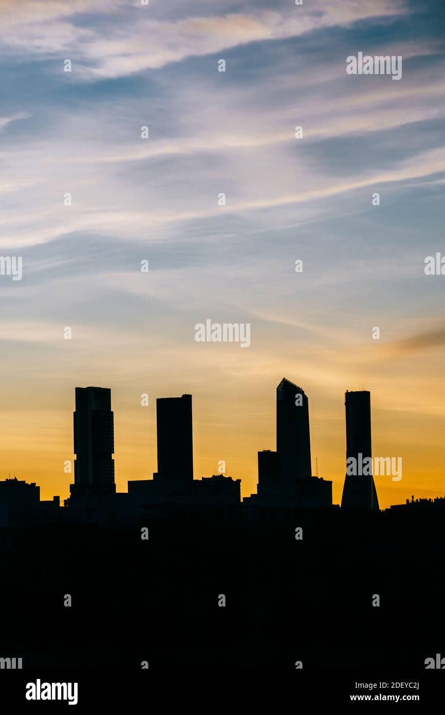 Cuatro Torres Business Area skyline di Madrid al tramonto con alto contrasto in verticale. Toni arancione e blu. Foto Stock