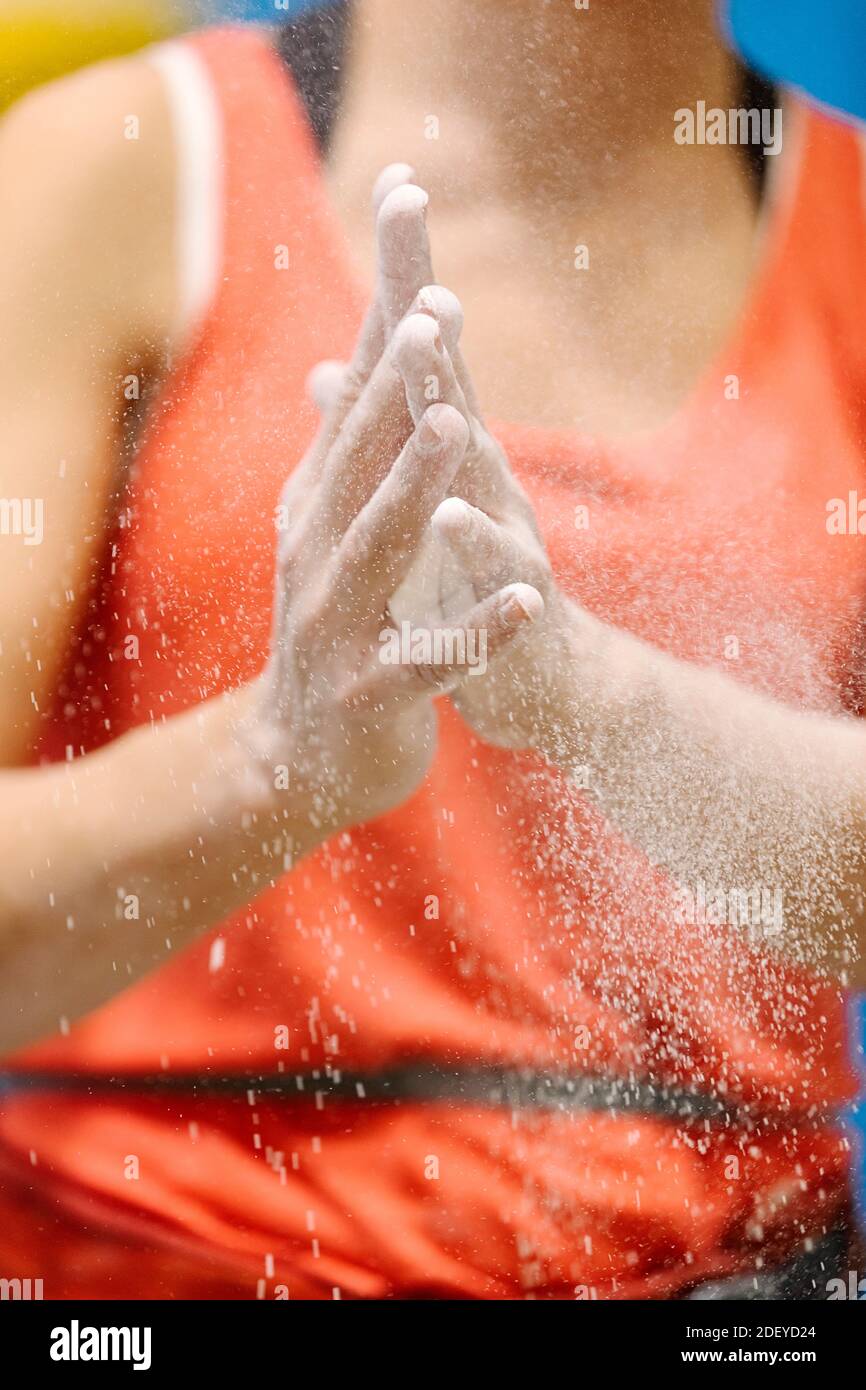 Foto d'inventario di una donna adulta che calca le mani prima di arrampicarsi su roccia. Solo le sue mani sono viste, è irriconoscibile. Foto Stock