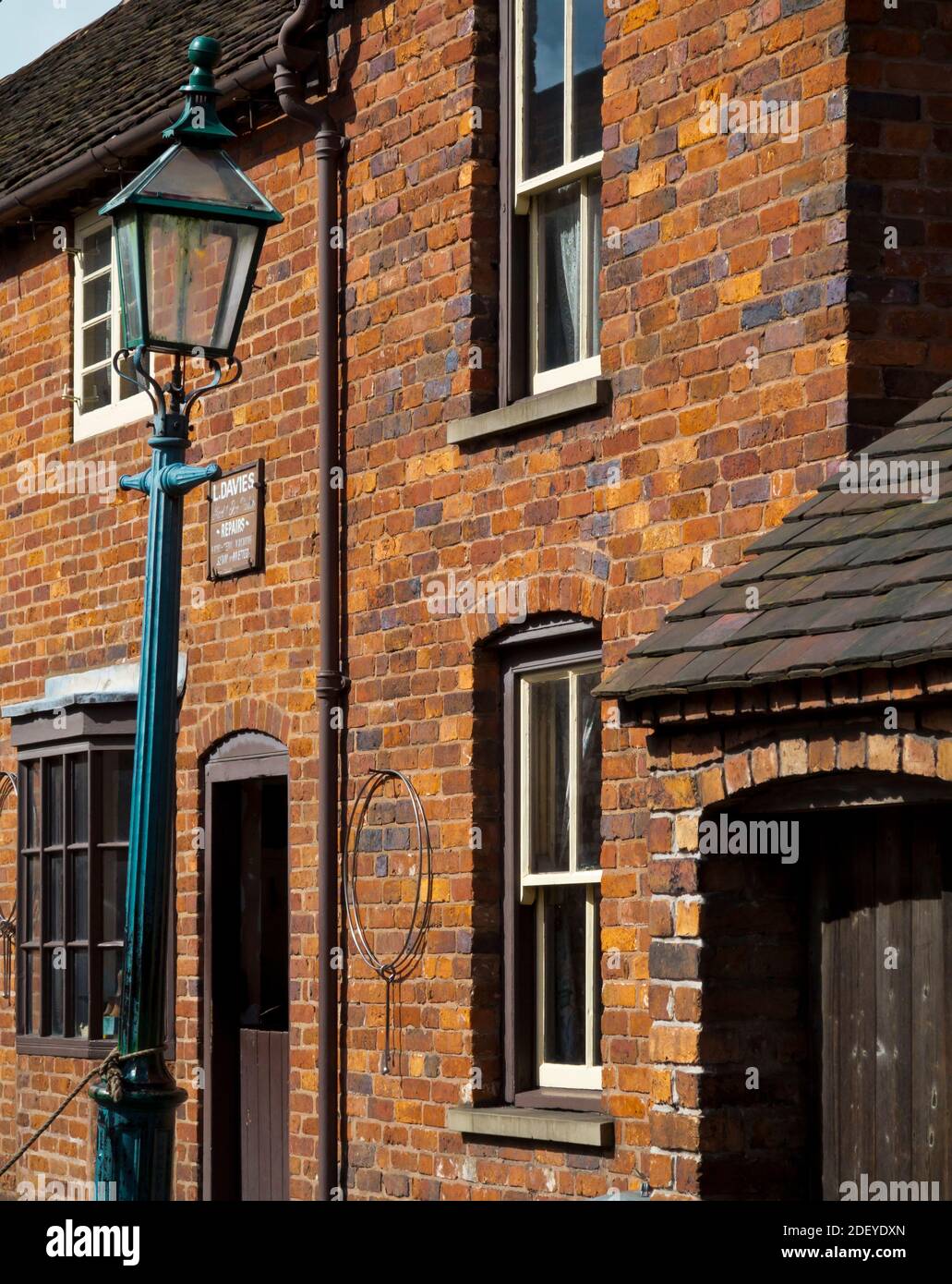 Case a schiera in mattoni rossi e tradizionale lampada da strada su un street al Black Country Living History Museum di Dudley West Midlands Inghilterra Regno Unito Foto Stock